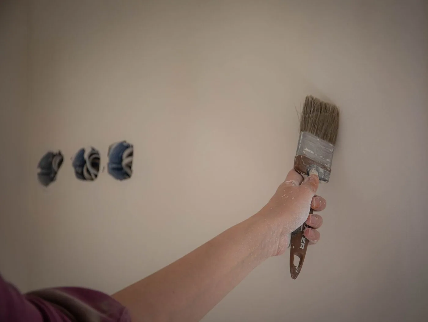 Painter cutting in a clean line along the edge of a wall